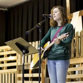 Image of woman playing guitar at a ChristLife session.
